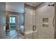 Modern tiled shower with glass door and built-in shelving next to a doorway to the bedroom at 1080 Gaithers Rd, Mansfield, GA 30055