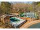 Aerial view showcases a community pool and tennis courts set amidst a lush, wooded landscape at 3476 Silver Maple Dr, Duluth, GA 30096