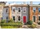 Charming townhome with a stucco facade, red front door, and manicured landscaping at 3476 Silver Maple Dr, Duluth, GA 30096