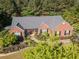 Aerial view of a red brick home with lush landscaping and a cozy front porch at 522 Plantation Creek Dr, Loganville, GA 30052