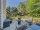 Back patio has comfortable seating, grill, and a view of the large backyard and mature trees, perfect for relaxing or entertaining at 522 Plantation Creek Dr, Loganville, GA 30052