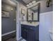 Bathroom with a dark vanity and decorations on the walls, and a door to another room at 522 Plantation Creek Dr, Loganville, GA 30052