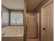 Bathroom with a bathtub, frosted glass shower door, and a white door at 522 Plantation Creek Dr, Loganville, GA 30052