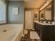 Bathroom featuring soaking tub, framed mirror, and plank flooring at 522 Plantation Creek Dr, Loganville, GA 30052