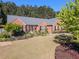 Scenic view of a red brick home with landscaped front yard and red front door at 522 Plantation Creek Dr, Loganville, GA 30052