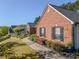 Side view of red brick home with manicured landscaping and a walkway leading to the front at 522 Plantation Creek Dr, Loganville, GA 30052