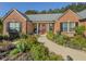 Beautiful red brick home with a red front door, black shutters, and charming landscaping at 522 Plantation Creek Dr, Loganville, GA 30052