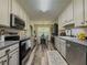 Bright kitchen featuring stainless steel appliances, painted cabinets, and a connected dining area at 522 Plantation Creek Dr, Loganville, GA 30052