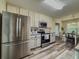 Modern kitchen featuring stainless steel appliances, painted cabinets, and plank flooring at 522 Plantation Creek Dr, Loganville, GA 30052