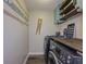 Convenient laundry room includes washer, dryer, folding table, upper cabinets and shelves, and cute laundry decor at 522 Plantation Creek Dr, Loganville, GA 30052