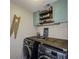 Convenient laundry room includes washer, dryer, folding table, upper cabinets and shelves, and cute laundry decor at 522 Plantation Creek Dr, Loganville, GA 30052