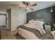 Comfortable main bedroom features a neutral color palette, accent wall, ceiling fan, and a view to the hall and the en suite at 522 Plantation Creek Dr, Loganville, GA 30052