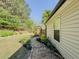 Landscaped side yard with manicured lawn, walkway, and garden provides a beautiful transition to the backyard at 522 Plantation Creek Dr, Loganville, GA 30052