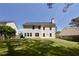 Back exterior view of home with a large, flat, grassy yard and wood fencing at 1553 Pinebreeze Dr, Marietta, GA 30062