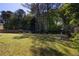Grassy back yard surrounded by mature trees and a wood fence at 1553 Pinebreeze Dr, Marietta, GA 30062