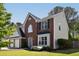 Two-story home with brick and siding, featuring a manicured lawn and blooming flowers at 1553 Pinebreeze Dr, Marietta, GA 30062