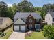 View of a two-story home with a well-maintained lawn and an attached two-car garage at 1553 Pinebreeze Dr, Marietta, GA 30062