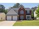 Charming two-story home with brick facade, attached two car garage and well-manicured lawn at 1553 Pinebreeze Dr, Marietta, GA 30062
