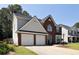 Two-story home features a brick facade, a two-car garage, and manicured landscaping at 1553 Pinebreeze Dr, Marietta, GA 30062