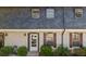 Charming townhouse featuring a brick facade, gray roofing, and well-maintained front yard landscaping at 305 Stonecliff Ct, Stone Mountain, GA 30083