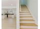 Staircase leading to kitchen with laminate floors, white cabinetry, dark countertops, and neutral paint at 305 Stonecliff Ct, Stone Mountain, GA 30083