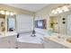 Bright bathroom featuring a large soaking tub, double sinks, mirrors, and a large window at 1337 Highfield Dr, Lawrenceville, GA 30043