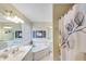 Bathroom featuring a soaking tub, double sinks, a shower with a curtain, and decorative artwork at 1337 Highfield Dr, Lawrenceville, GA 30043