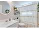 Bright bathroom featuring a white vanity, toilet, decorative accents, and a shower with a floral curtain at 1337 Highfield Dr, Lawrenceville, GA 30043
