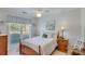 Cozy bedroom featuring a full-size bed, wood nightstand, a window, and a ceiling fan for comfort at 1337 Highfield Dr, Lawrenceville, GA 30043
