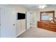 Bedroom features a mounted TV, closet, door leading to the bathroom, and a dark wood dresser with mirror at 1337 Highfield Dr, Lawrenceville, GA 30043
