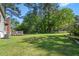 Expansive backyard with lush green grass, mature trees, and a wooden deck area at 2062 Skyhawk Ln, Acworth, GA 30102