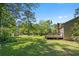Large backyard with green grass, mature trees, and a wooden deck attached to the house at 2062 Skyhawk Ln, Acworth, GA 30102