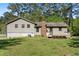 Backyard view of home with a brick chimney, wood deck, and lush green lawn at 2062 Skyhawk Ln, Acworth, GA 30102