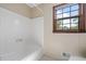 Bathroom with a white tub and shower combination, featuring a bright window at 2062 Skyhawk Ln, Acworth, GA 30102