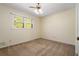 A cozy bedroom with neutral carpet, a ceiling fan, and natural light from a window at 2062 Skyhawk Ln, Acworth, GA 30102