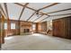 Spacious living room with a brick fireplace, wooden paneling, beamed ceiling, and neutral carpeting at 2062 Skyhawk Ln, Acworth, GA 30102