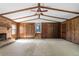Bright, carpeted living room with wood paneling, brick fireplace and beams on the ceiling at 2062 Skyhawk Ln, Acworth, GA 30102