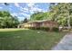 A side angle view of a charming brick home with green lawn and mature trees at 2844 Whispering Hills Dr, Chamblee, GA 30341