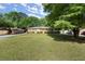 A view of the well-maintained front yard of a traditional brick home with mature trees at 2844 Whispering Hills Dr, Chamblee, GA 30341
