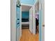 Hallway with view of furnished bedroom featuring blue walls and hardwood floors at 2844 Whispering Hills Dr, Chamblee, GA 30341