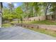 Landscaped backyard with a patio, brick retaining wall, green lawn, and wooden fence at 4785 Longchamps Dr, Sandy Springs, GA 30319