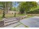 Landscaped backyard featuring a bluestone patio, brick steps and retaining wall, and green lawn at 4785 Longchamps Dr, Sandy Springs, GA 30319