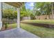Scenic backyard featuring a covered patio, green lawn, brick retaining wall and a wooden fence at 4785 Longchamps Dr, Sandy Springs, GA 30319