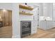 Wet bar features wine refrigerator, white cabinets, floating shelves, and hardwood floors at 4785 Longchamps Dr, Sandy Springs, GA 30319