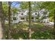 View of the home from the front yard, framed by lush trees, well-manicured lawn, and modern accents at 4785 Longchamps Dr, Sandy Springs, GA 30319