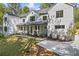 Stunning two-story home featuring a black roof, black framed windows, white siding and a covered front porch at 4785 Longchamps Dr, Sandy Springs, GA 30319