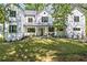 Stunning white two-story home featuring a lush green lawn, large windows, and inviting front porch at 4785 Longchamps Dr, Sandy Springs, GA 30319