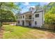 Rear exterior view with a yard, a wooden fence, large windows, and a second story balcony at 4785 Longchamps Dr, Sandy Springs, GA 30319