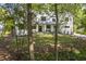 A luxurious home set on a sprawling green lawn, framed by lush trees, and a long driveway at 4785 Longchamps Dr, Sandy Springs, GA 30319