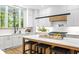 Stunning kitchen with an island, white cabinetry, black bar stools, and stainless steel appliances at 4785 Longchamps Dr, Sandy Springs, GA 30319